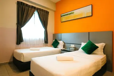 a hotel room with two beds and a window at Travelland Hotel in Ipoh