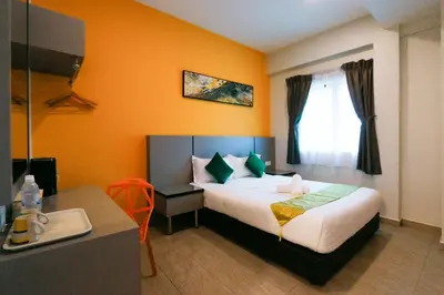 a hotel room with a bed and a desk at Travelland Hotel in Ipoh