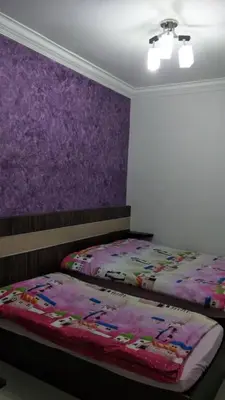 a bedroom with a bed with a purple wall at Rose Apartment Kea Farm in Cameron Highlands