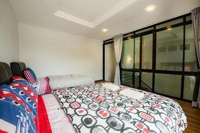 a bedroom with a bed and a large window at New Shamrock Beach Villas Seaview in Batu Ferringhi
