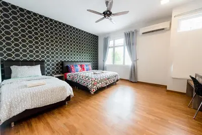 a bedroom with a bed and a couch and a fan at New Shamrock Beach Villas Seaview in Batu Ferringhi