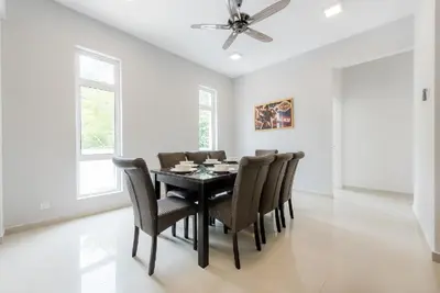 a dining room with a black table and chairs at New Shamrock Beach Villas Seaview in Batu Ferringhi