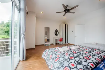 a bedroom with a bed and a ceiling fan at New Shamrock Beach Villas Seaview in Batu Ferringhi