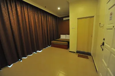 a room with a bed and a hallway with a door at Gurney Inn in George Town