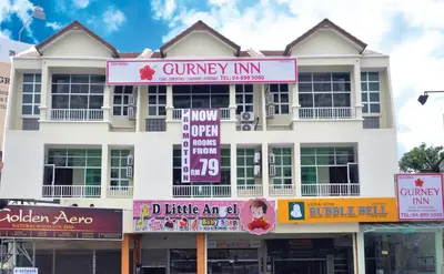 a white building with signs in front of it at Gurney Inn in George Town