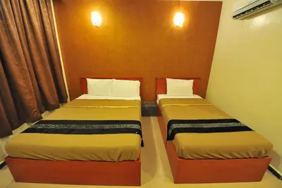 two beds sitting next to each other in a room at Gurney Inn in George Town
