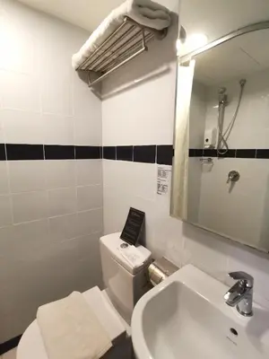a bathroom with a sink and a toilet and a mirror at Kimberley Hotel Georgetown in George Town