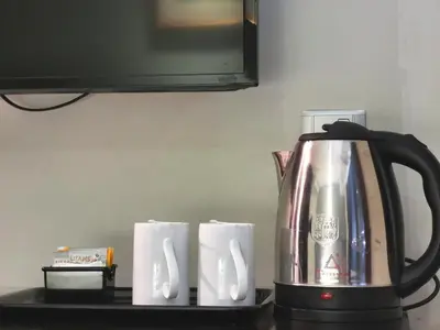 a coffee pot and some paper towels on a counter at Kimberley Hotel Georgetown in George Town