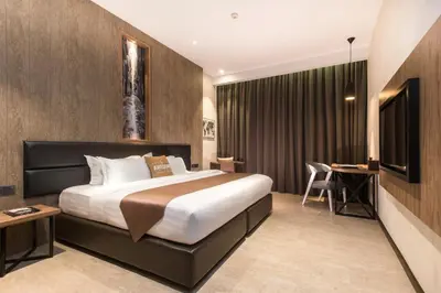 a hotel room with a bed and a desk at Iconic Hotel in Bukit Mertajam