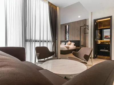 a living room with a couch and chairs and a bed at Iconic Hotel in Bukit Mertajam