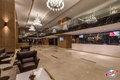 a lobby with chairs and chandeliers in a building at Iconic Hotel in Bukit Mertajam