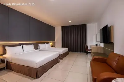 a hotel room with two beds and a flat screen tv at One Pacific Hotel and Serviced Apartments in George Town