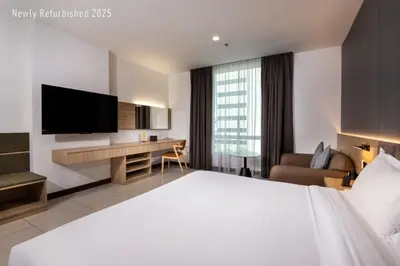 a hotel room with a large bed and a television at One Pacific Hotel and Serviced Apartments in George Town