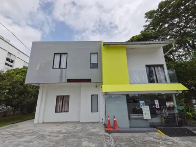 a white and yellow building with orange cones in front at Gurney Lodge in George Town