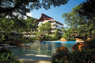 a resort with a swimming pool in front of a building at Shangri-La Rasa Sayang, Penang in Batu Ferringhi