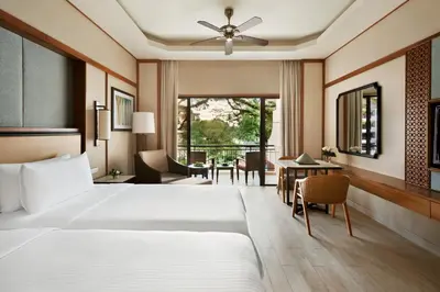 a hotel room with a bed and a table and chairs at Shangri-La Rasa Sayang, Penang in Batu Ferringhi