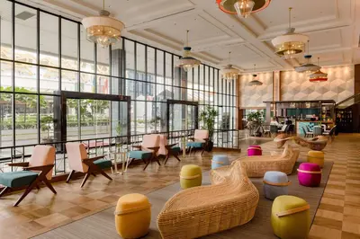 a lobby with chairs and tables and windows at JEN Penang Georgetown by Shangri-La in George Town