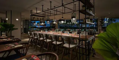 a long bar with chairs and tables in a restaurant at JEN Penang Georgetown by Shangri-La in George Town