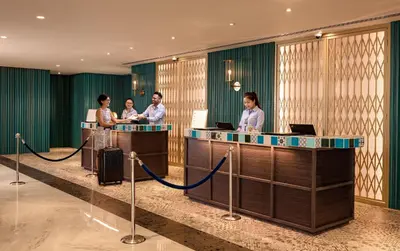 a group of people standing in a lobby with luggage at JEN Penang Georgetown by Shangri-La in George Town