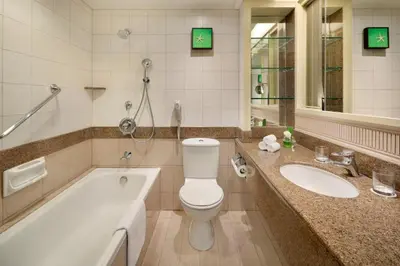 a bathroom with a tub and a toilet and a sink at Shangri-La Golden Sands, Penang in Batu Ferringhi