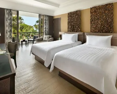 two beds in a hotel room with a balcony at Shangri-La Golden Sands, Penang in Batu Ferringhi