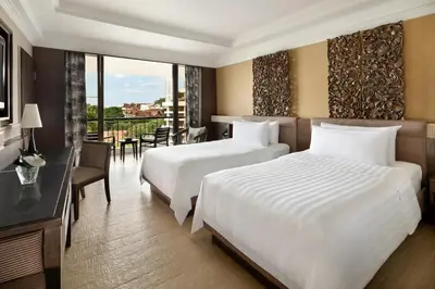a hotel room with two beds and a balcony at Shangri-La Golden Sands, Penang in Batu Ferringhi
