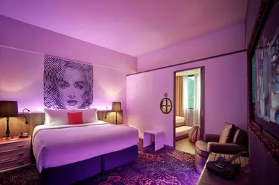 a purple bedroom with a bed and a chair at Hard Rock Hotel Penang in Batu Ferringhi