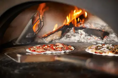 two pizzas are cooking in a brick oven at Hard Rock Hotel Penang in Batu Ferringhi