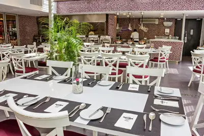 a dining room with white tables and white chairs at Hard Rock Hotel Penang in Batu Ferringhi