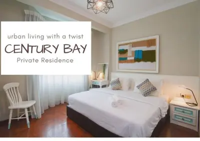 a bedroom with a white bed and a white chair at Century Bay Private Residences in Bayan Lepas