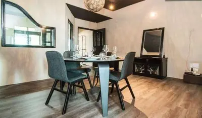 a dining room with a table and chairs and a mirror at Century Bay Private Residences in Bayan Lepas