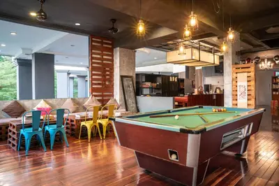 a living room with a pool table and chairs at Century Bay Private Residences in Bayan Lepas