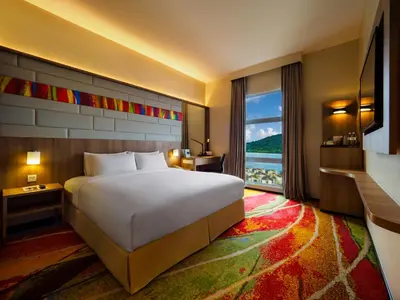 a hotel room with a bed and a large window at Eastin Hotel Penang in Bayan Lepas