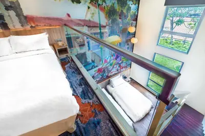 a room with a bed and stairs with a mural at Eastin Hotel Penang in Bayan Lepas