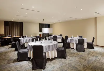 a banquet room with tables and chairs with white table cloth at Eastin Hotel Penang in Bayan Lepas