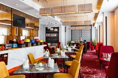 a restaurant with tables and chairs and a bar at Eastin Hotel Penang in Bayan Lepas