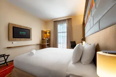 a hotel room with a bed and a tv at Eastin Hotel Penang in Bayan Lepas