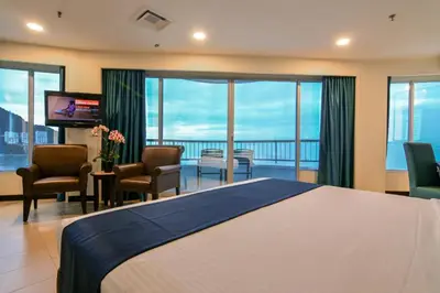a hotel room with a large bed and a balcony at Flamingo Hotel by the Beach, Penang in George Town