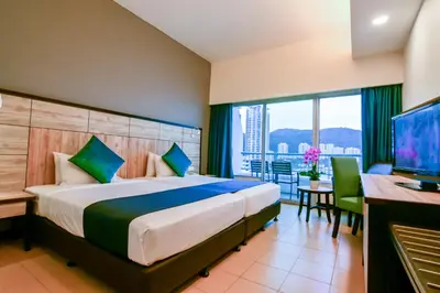 a hotel room with a bed and a desk and a television at Flamingo Hotel by the Beach, Penang in George Town