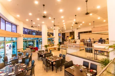 a restaurant with tables and chairs in a building at Flamingo Hotel by the Beach, Penang in George Town