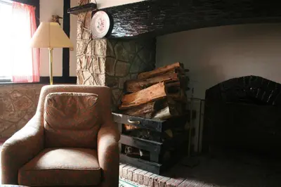 a room with a chair and a pile of logs at The Smokehouse Hotel & Restaurant Cameron Highlands in Cameron Highlands