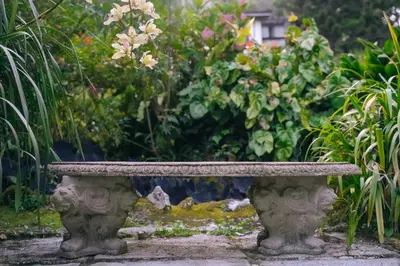 a stone bench sitting in the middle of a garden at The Smokehouse Hotel & Restaurant Cameron Highlands in Cameron Highlands