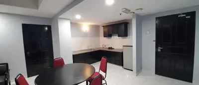a kitchen with a black table and red chairs at Leisure Cove Hotel and Apartments in George Town