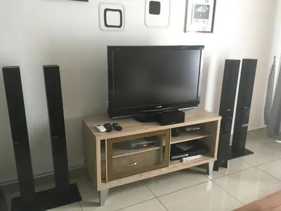 a flat screen tv on a stand with speakers at The Majestic condo Ipoh in Ipoh