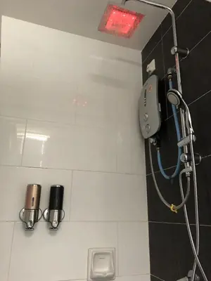 a shower in a bathroom with a red light at The Majestic condo Ipoh in Ipoh