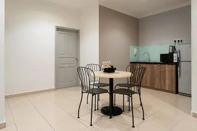 a kitchen with a table with chairs and a refrigerator at Golden View Serviced Apartments in George Town