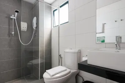 a bathroom with a shower and a toilet and a sink at Golden View Serviced Apartments in George Town