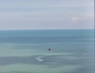 an island in the ocean with a red umbrella at Green Ocean Seaview Apartment in Batu Ferringhi