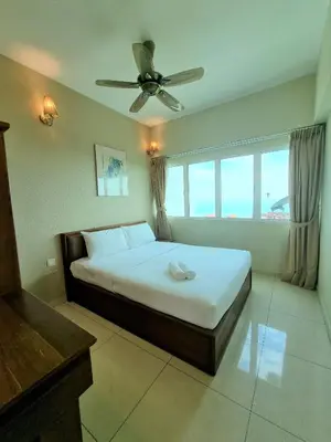 a bedroom with a bed and a ceiling fan at Green Ocean Seaview Apartment in Batu Ferringhi