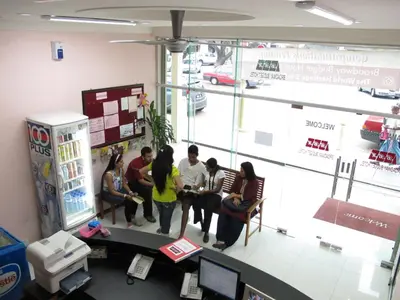 a group of people sitting around a table in a room at Broadway Budget Hotel in George Town
